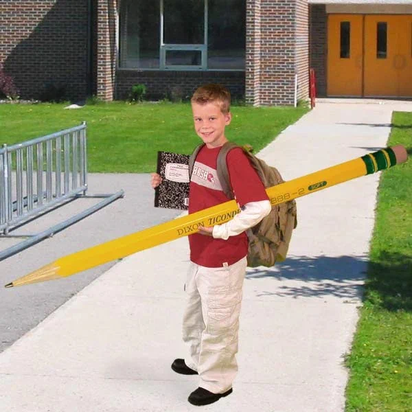 cheeky little kid holding a giant pencil.