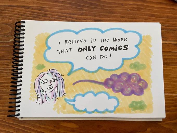 A sketchy pen & ink drawing in a sketchbook, of a Caucasian woman with long hair and glasses, saying "I believe in the work that ONLY COMICS can do!" The words appear in a word bubble, and there are a few other empty, wordless word bubbles floating around too.