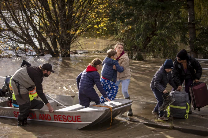 Alandra Meier, Rudi and Bekky's daughter, helps her family members out of a search and rescue boat after being rescued from an area that was cut off due to flooding in Abbotsford, British Columbia on Tuesday, November 16, 2021. 