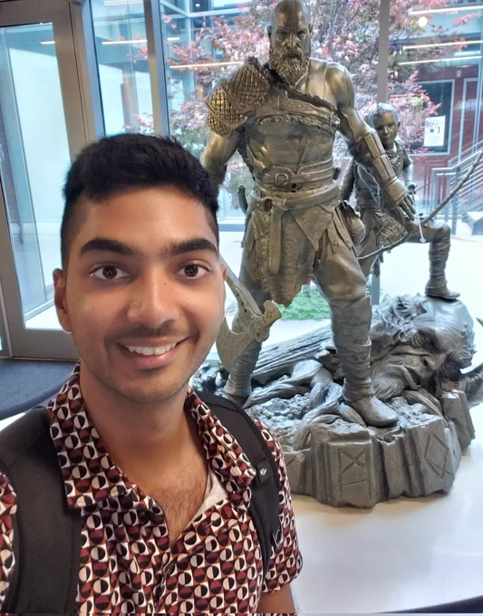 Me in 2022 in front of a Kratos and Atreus statue