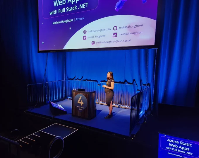 Melissa on stage with her title slide for her Static Web Apps talk