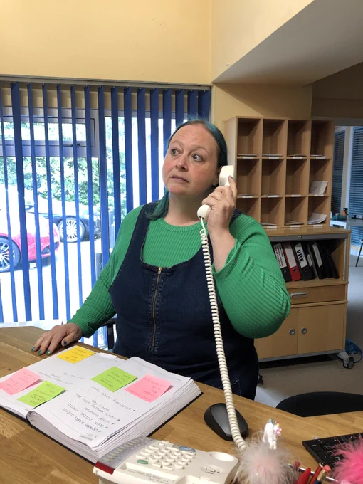 Me, behind the desk at The Mill, holding the phone to my ear.
