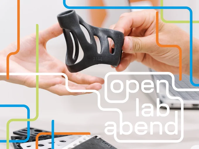 Bild: Eine Hand reicht der anderen ein schwarzes Modell aus dem 3D-Drucker. Es ist asymmetrisch geformt und hat gleichmäßige Löcher im Körper. Im Hintergrund ist ein Laptop verschwommen zu sehen. Darüber das OLA-Keyvisual: Orange, grüne und blaue Rohre zieren das Bild an den Seiten. Aus weißen Rohren entsteht die Schrift „open lab abend“.