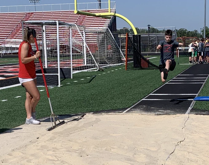 student jumping in the air for the long jump