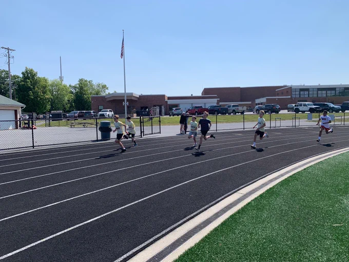 group of students running on an outdoor track