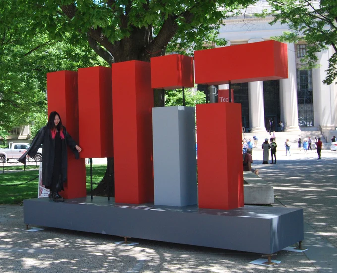 Woman standing on MIT large MIT sign