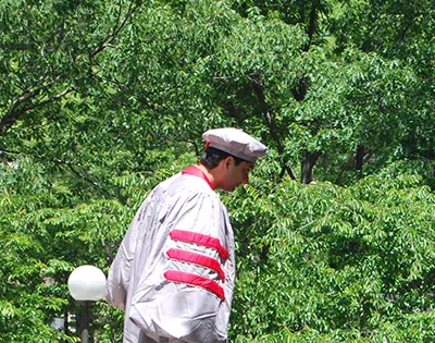 Man wearing a gray cap and gown