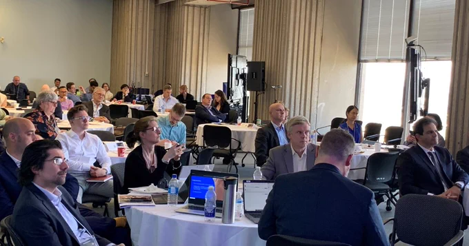 Interior shot of conference with participants seated.