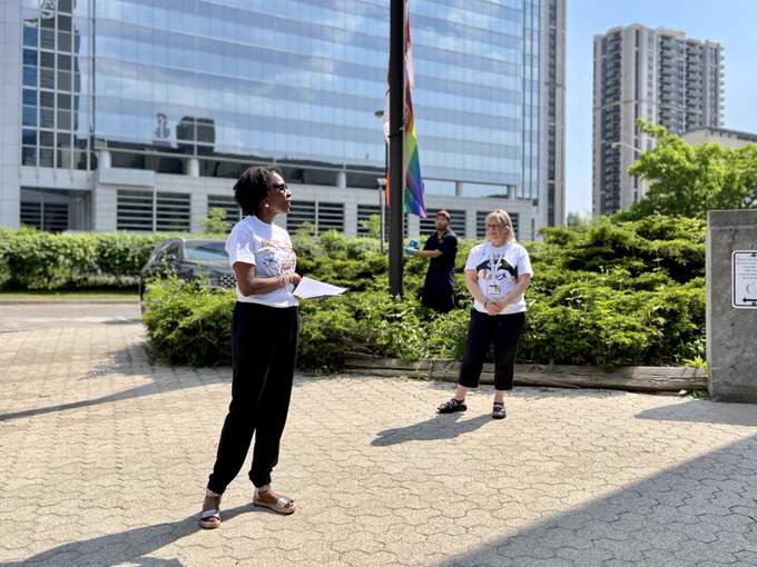 The Director of Education spoke to the attendees outside, as the Chair and a staff member are seen in the background.