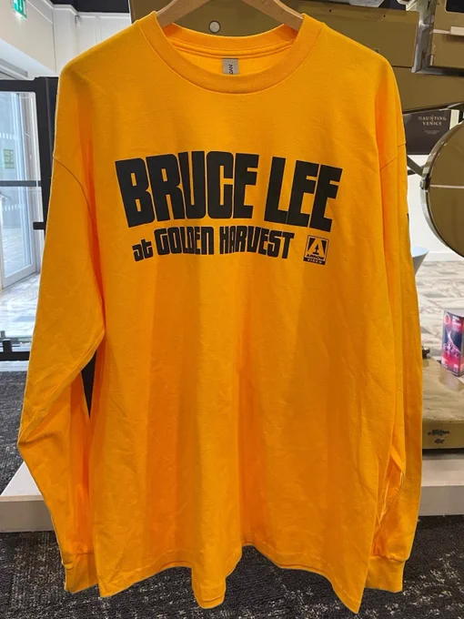 A yellow long sleeved Bruce Lee at Golden Harvest shirt
