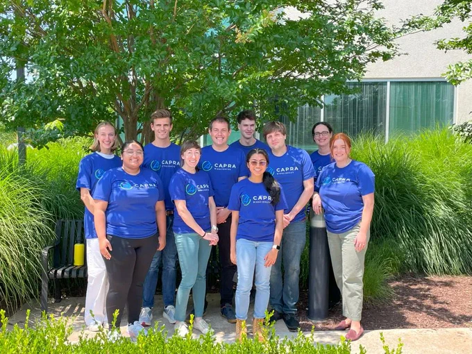 The Capra team stands outside in matching blue t-shirts.