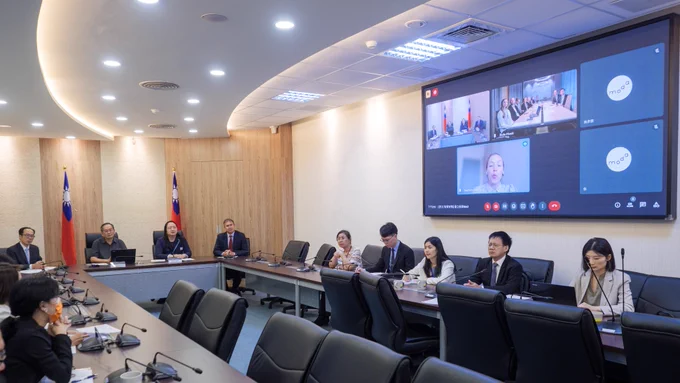 Officials and staffers from the Ministry of Digital Affairs and National Institute of Cyber Security, as well as the Ministry of the Economy and Innovation, are seated in a meeting room at moda HQ in Taipei.