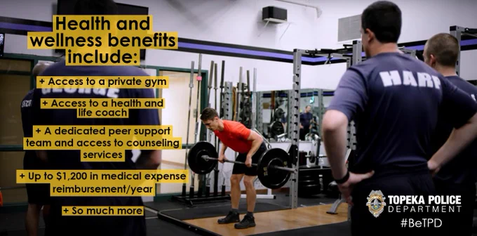 Several police officers stand in a gym and watch a weightlifting demonstration. The graphic reads, "Health and wellness benefits include:/Access to a private gym/Access to a health and life coach/A dedicated peer support team and access to counseling services/Up to $1,200 in medical expense reimbursement/year/So much more"