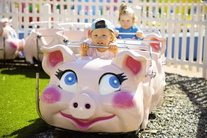Child on pig themed ride at piggy town Sarkanniemi
