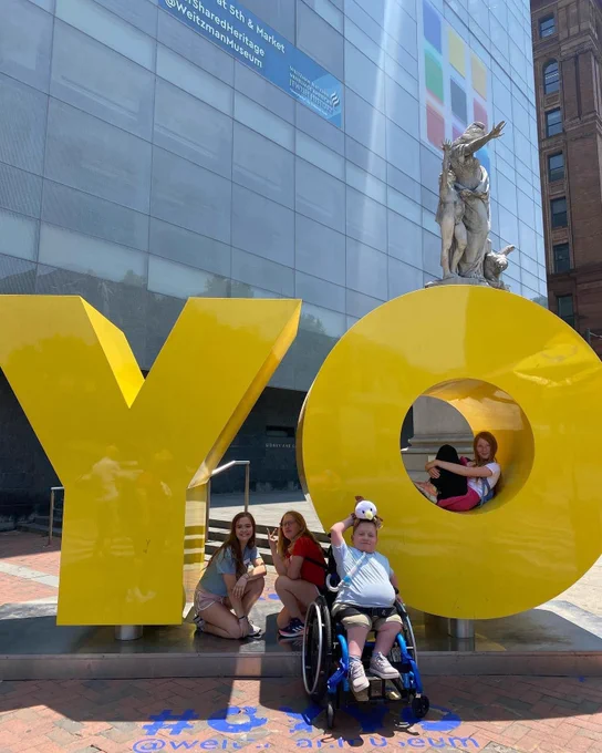 Giant yellow letters that say, 'YO' with several students posing around them