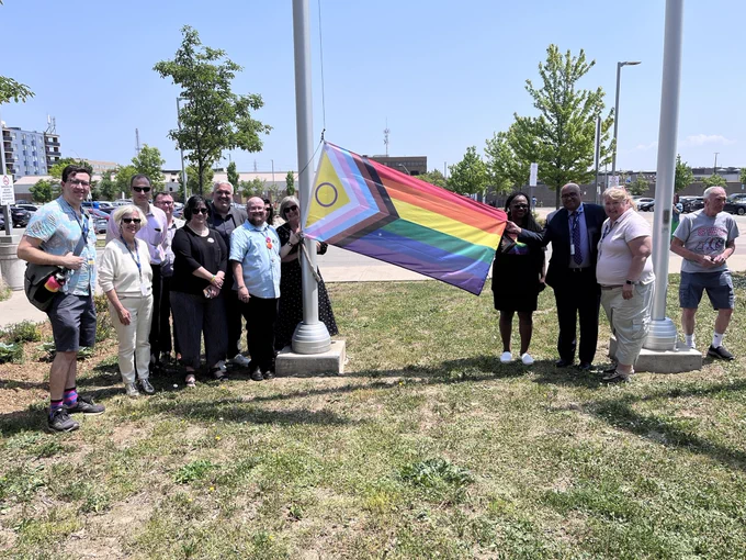 HWDSB staff and I standing in front of the Education Centre with the Intersex-Inclusive Progressive Flag.
