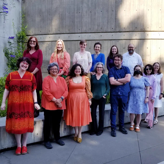 Library staff dressed in rainbow colors outside the library exterior wall.