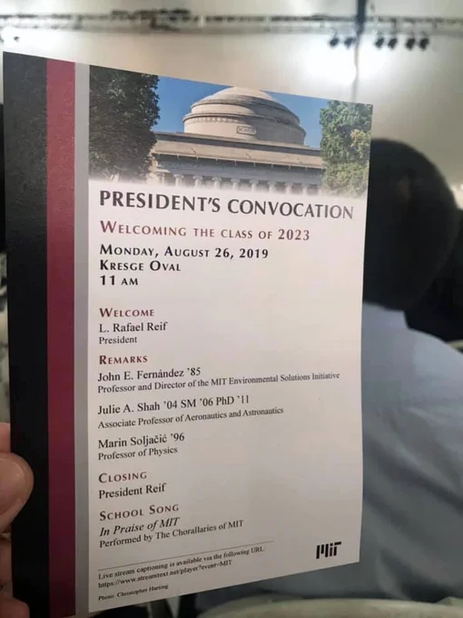 A hand holding up the program for the President’s Convocation for the class of 2023.