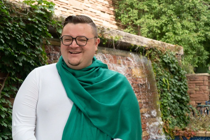 Alex Lange stands near the waterfall outside of the CSU Education building.