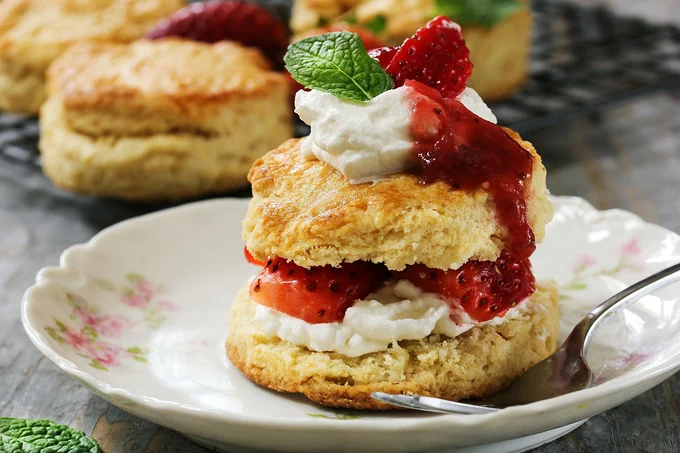 strawberry shortcake sitting on a plate with a fork. 