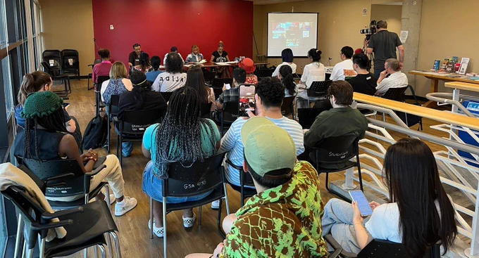 A crowd of more than 30 people listening to a panel describing the challenges of being Black at York University.