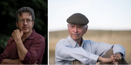 George Monbiot (credit ©Guy Reece) and Allan Savory. George (left) wearing glasses and a burgundy shirt, has his arms folded. Allan wears a flat cap and a blue checked shirt, sits on the ground with his arms resting on raised knees