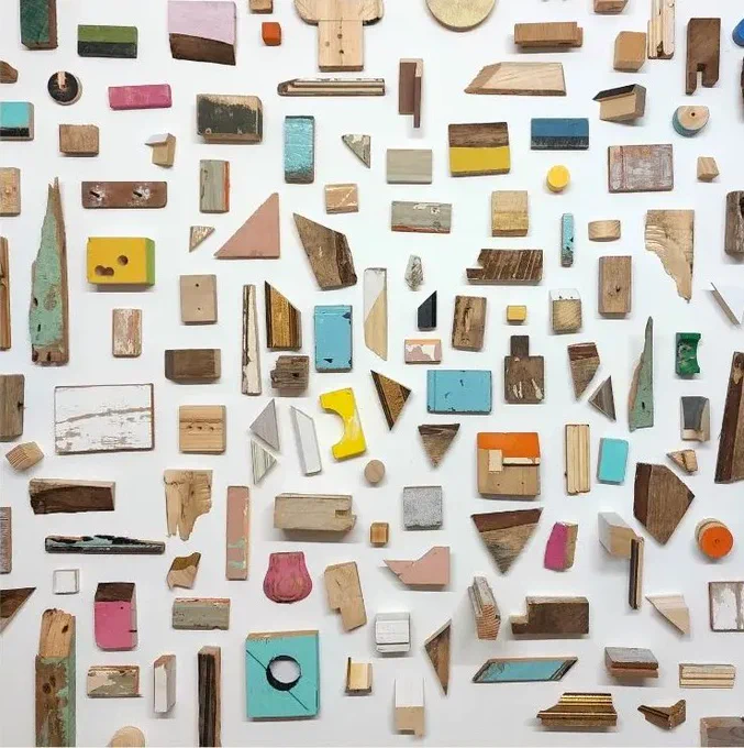 Image: photo of bits of wood, fairly old and worn-looking, most with some paint on them; maybe 100 pieces arranged in a very loose grid • "Mary Butler’s current work includes assemblages, arrangements & sculptures. Her work is non-representational, focusing on colour, shape, texture, size and scale. Throughout her work she is experimenting with aleatoric processes, making spontaneous decisions and emphasising the conscious process of composition. Mary also focusses on the significance of the negative spaces, the breathing spaces between objects, and the impact of this on her structures and arrangements.    Mary Butler is the Winner of the Solo Show 2022/2023 GOMA Gallery of Modern Art Award."