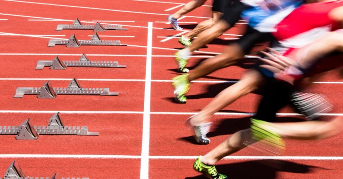 Runners leaving the start line on a track