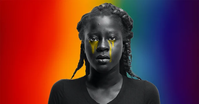 Black female crying. The background is a dusty pride flag