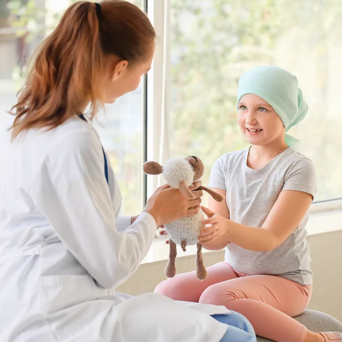 A photo of a young cancer patient interacting with a female physician.
