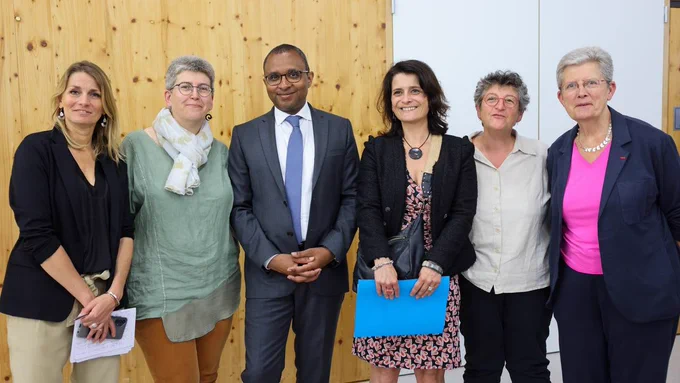 Photographie de groupe des ministres aux côtés de professionnels du médico-social. La ministre est à droite de l'image et Pap Ndiaye est au centre. À leurs côtés, des femmes regardent l'objectif et sont souriantes.