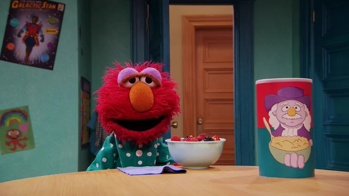 Elmo, sleepy, in front of his breakfast 