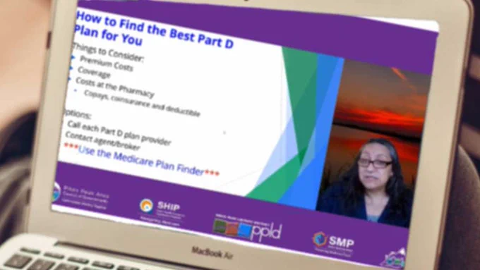 A laptop with the image of a webinar on the screen.