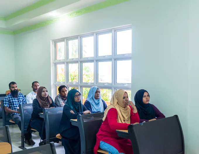 Participants from the local councils (both men and women) sit together in the classroom listening to lectures