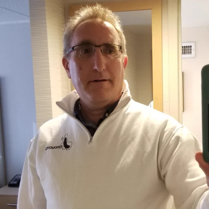I am wearing a white sweatshirt with the Jomoworks logo on it