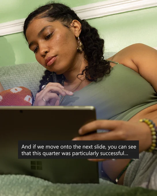 An image of a woman using automated captions on her Windows device.