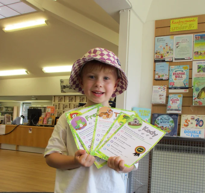 boy wearing bucket hat holding six cards
