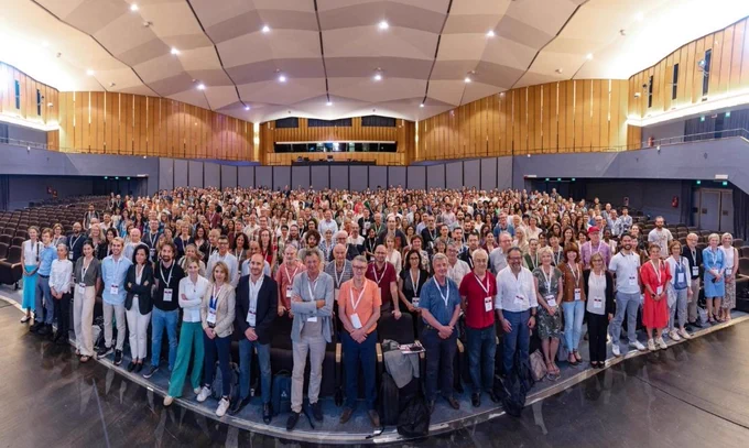 The image shows 821 people standing shoulder to shoulder in a large conference hall. 