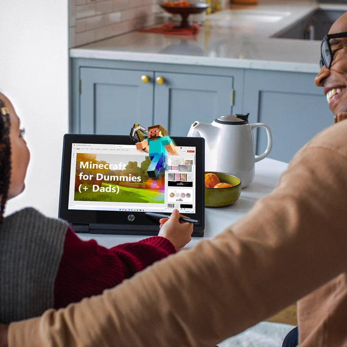 An image of a father and daughter looking at a PowerPoint presentation on how to play Minecraft.