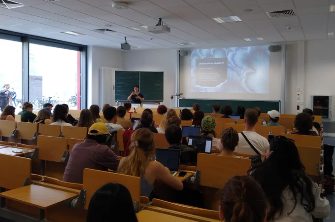 Gunjan Sondhi presenting her research on decolonising migration studies in front of a group of people sitting in a class room