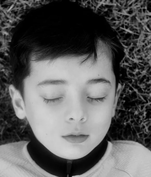 Image: black-and-white head-shot of young kid with eyes shut • "A photographic group exhibition offering glimpses into the lives and epiphanies of Dublin’s denizens • Ayesha Ahmad, Vivienne Dick, John Kelly, Paul Kelly, Philippe Gold, Adrian O’Carroll"