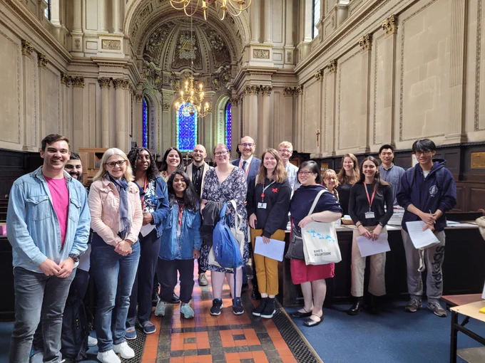 A group of King's staff and students standing in the aisle of St Mary le Stand church, with volunteers from the church.