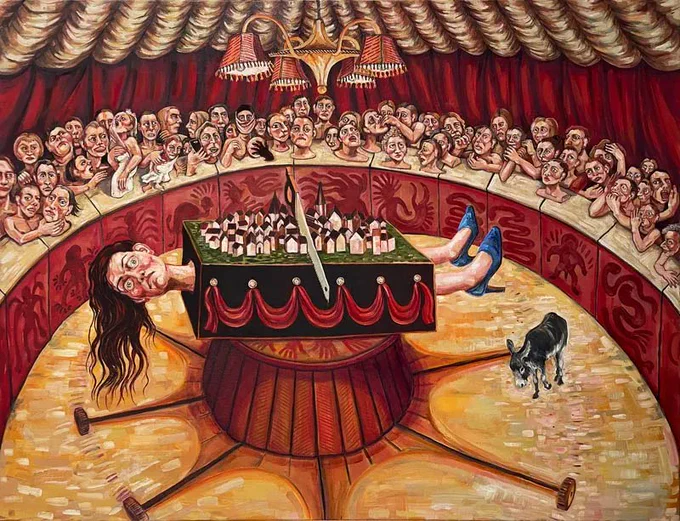 Image: Rita Duffy, Circus Animals' Desert, 2023, oil on linen, 65 x 90 cm © Rita Duffy –  strong colours, strong expressions; a figure with long hair wearing blue high-heel shoes is in a magician's box, with a saw resting on top, already having cut in a bit; on the box also is a model of a city, transected by the saw; there is a small donkey in the enclosure, but no magician; the figure looks very worried • "For her first solo exhibition at Crawford Art Gallery, artist Rita Duffy presents a trilogy of new, large-scale works that address urgent themes of planetary crisis and political chaos. This triptych for our times has its genesis in Duffy’s intense series of small, satirical drawings, The Emperor has No Clothes (2020), which was recently acquired by Crawford Art Gallery for the National Collection.    Rita Duffy (b.1959) is one of the major contemporary artists to emerge from Northern Ireland. Encompassing themes and images of Irish identity, history, and politics, her work is…"