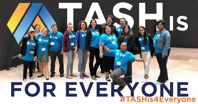 A group of TASH members, all wearing teal TASH t-shirts, in front of the Mountains and Clouds statue in the Hart Senate Office Building. The TASH Möbius strip in a blue and yellow gradient is behind them with the words TASH is for Everybody above and below.