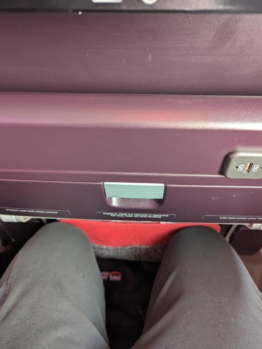 My knees up against the Virgin Atlantic seat back.