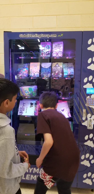 Boy getting book from vending machine 