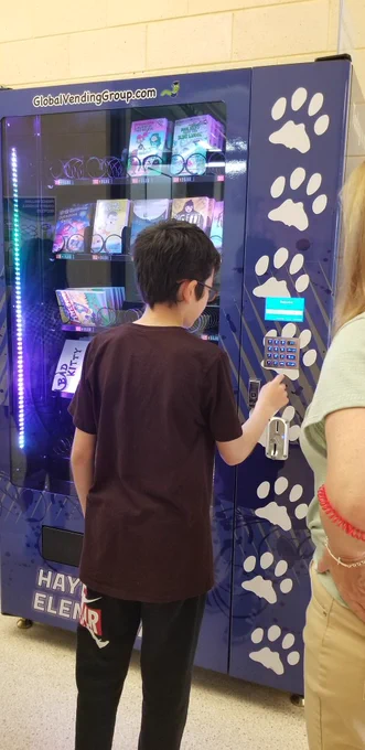 Boy pressing buttons on vending machine 