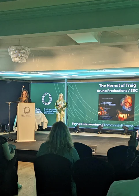 Torc Awards ceremony. The screen has a promotional image for The Hermit of Treig.
