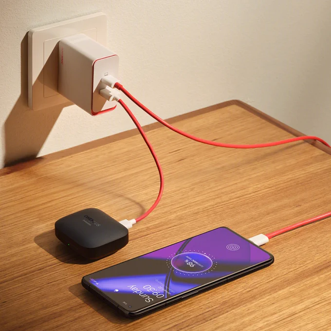 A OnePlus SUPERVOOC 100W Dual Ports Power Adapter charging a OnePlus 11 and a OnePlus Buds Pro 2