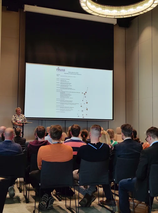 FINASin johtaja Katriina Luoma esittelemässä yleisölle asiakastapahtuman ohjelmaa. 